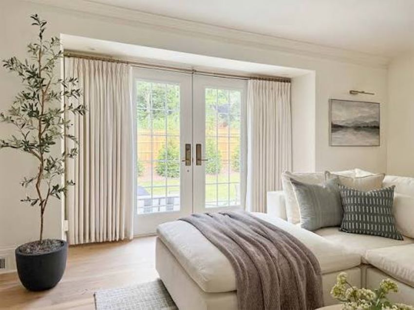 Modern sliding glass doors with elegant floor-length curtains in a living room